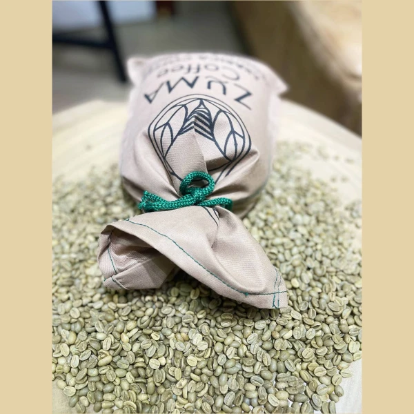 zuma sac of beans on top a pile of green coffee beans