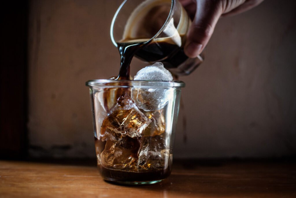 person-pouring-hot-coffee-glass-with-ice-make cold brew at home