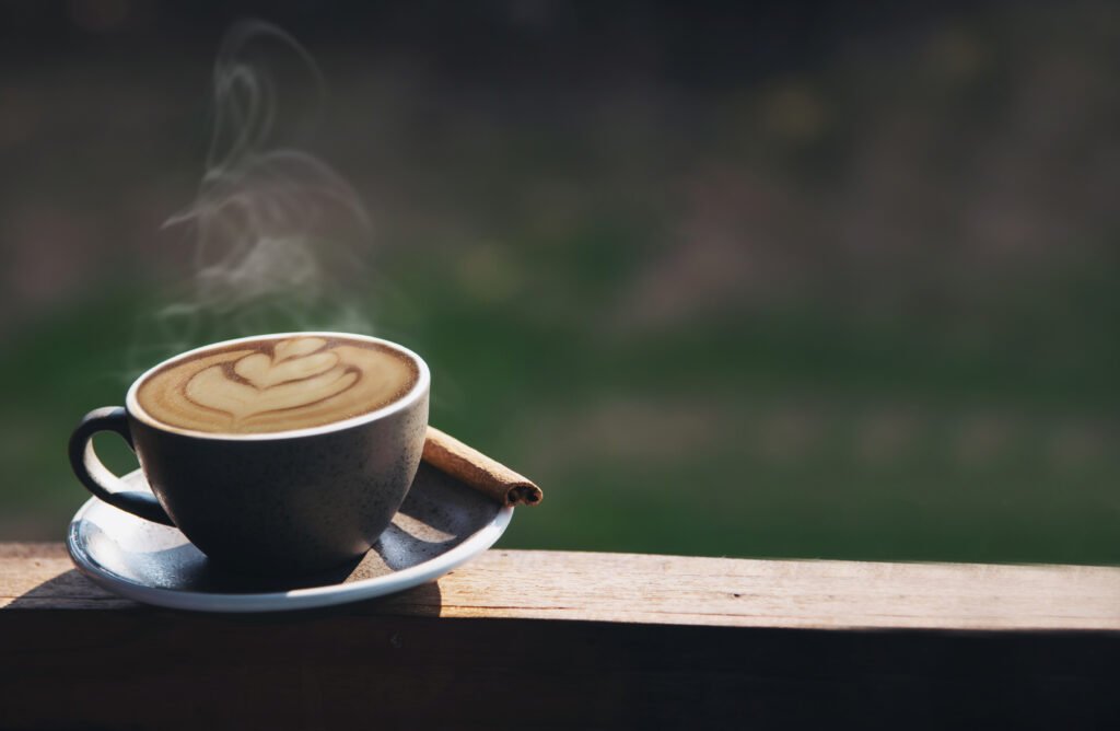 Cup of morning coffee with latte art sitting on a wooden plane