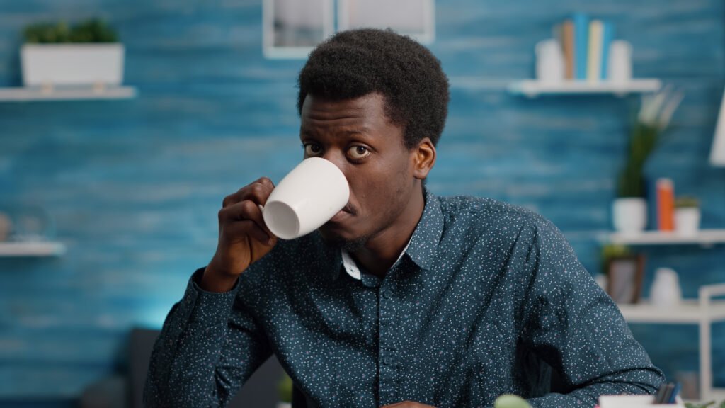 Man drinking from a whit mug