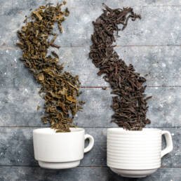 two white cups with dried leaves like double root coffee leaves