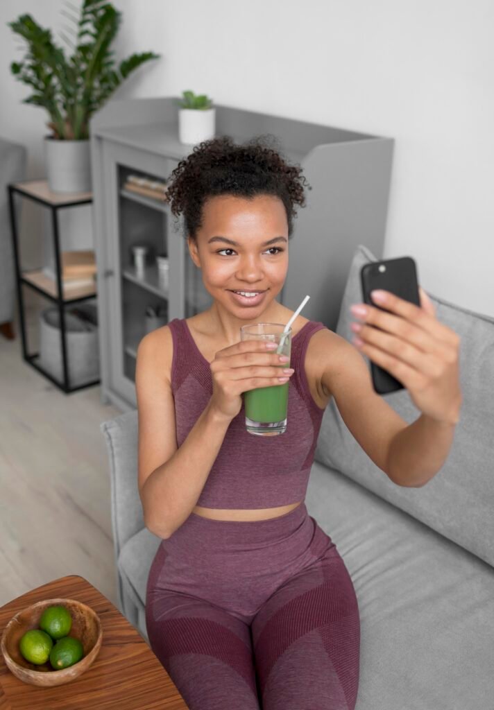 sports woman taking selfie holding glass of green juice. Good for coffee fast replacement