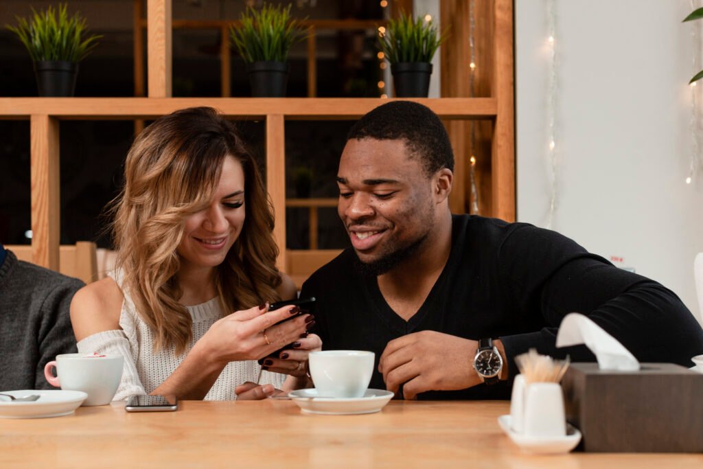 two cups of morning coffee with a man and woman looking in a cellphone